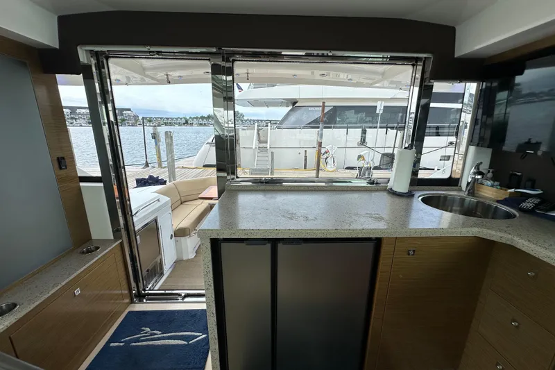 Slide: The Image of Interior view of 2013 Cruisers Yachts 45 Cantius, featuring a modern kitchen and open deck. - 13