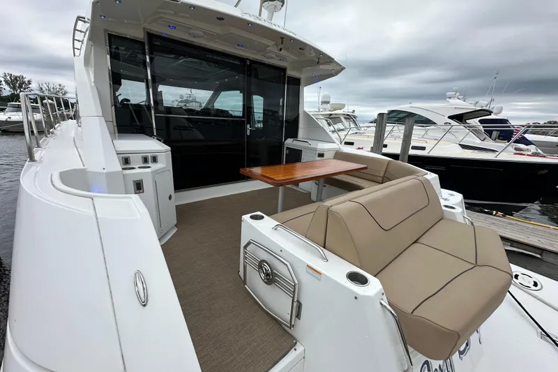 Slide: The Image of 2013 Cruisers Yachts 45 Cantius with outdoor seating and table, docked at marina. - 3
