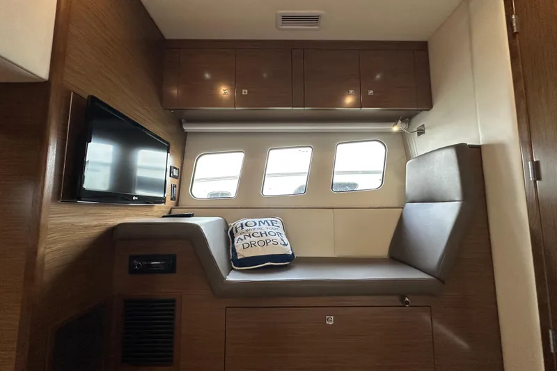Slide: The Image of 2013 Cruisers Yachts 45 Cantius interior with seating, TV, and nautical-themed pillow. - 34