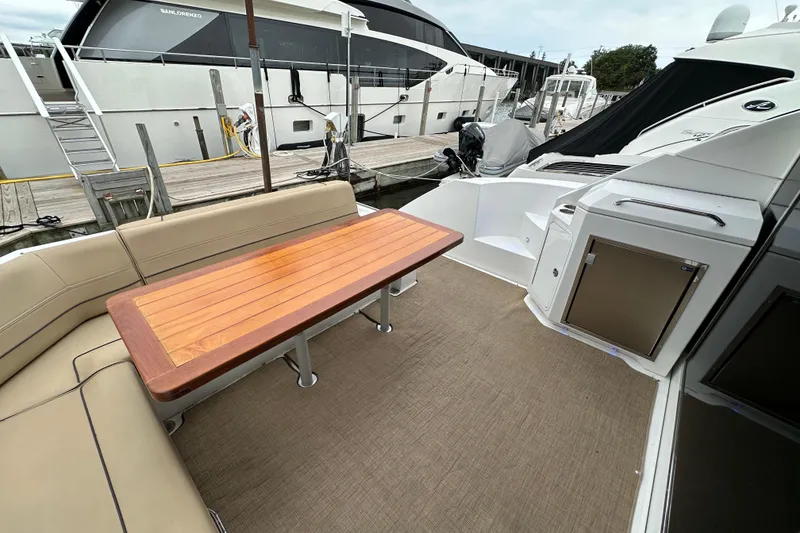 Slide: The Image of 2013 Cruisers Yachts 45 Cantius deck with seating and wooden table. - 5