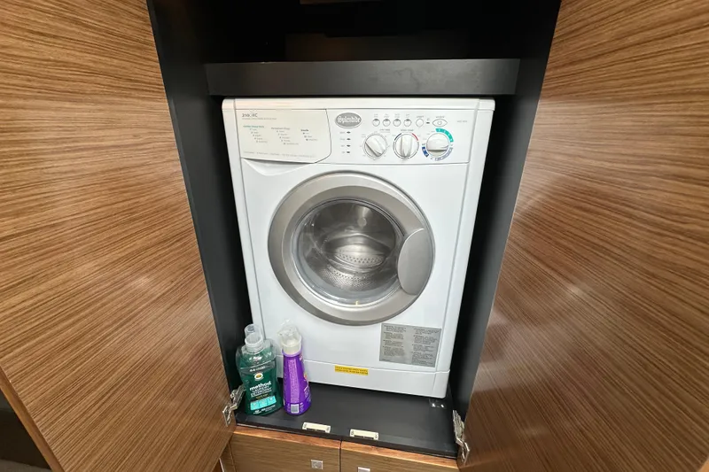 Slide: The Image of Washing machine inside 2013 Cruisers Yachts 45 Cantius, with wooden cabinetry and cleaning supplies. - 30