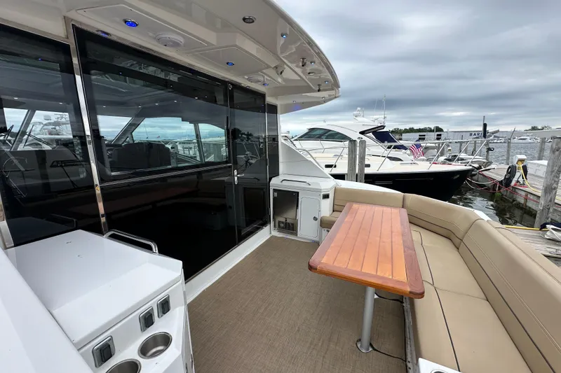 Slide: The Image of 2013 Cruisers Yachts 45 Cantius with outdoor seating and table, docked at marina. - 4