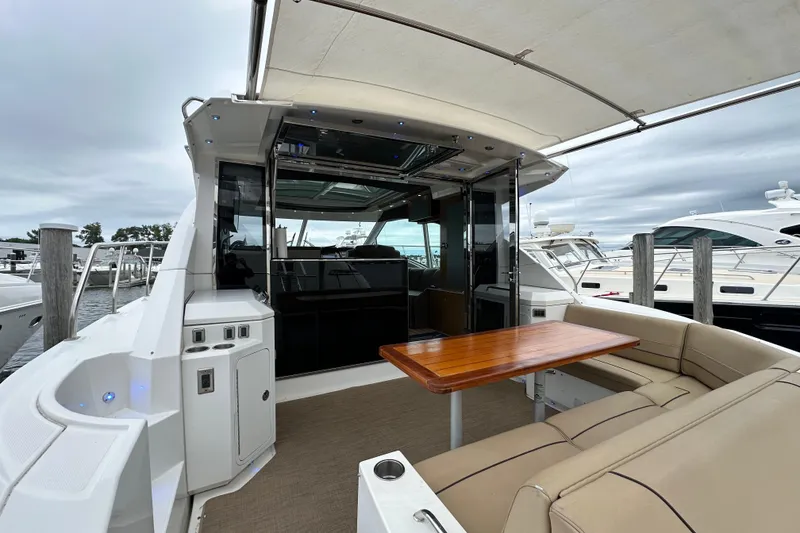 Slide: The Image of 2013 Cruisers Yachts 45 Cantius with outdoor seating and table at a marina. - 9