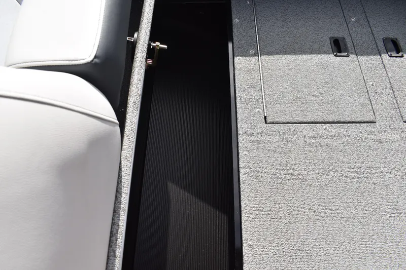 Slide: The Image of 2026 Lowe Sport Deck 224 interior storage compartment with gray carpet and seating. - 25