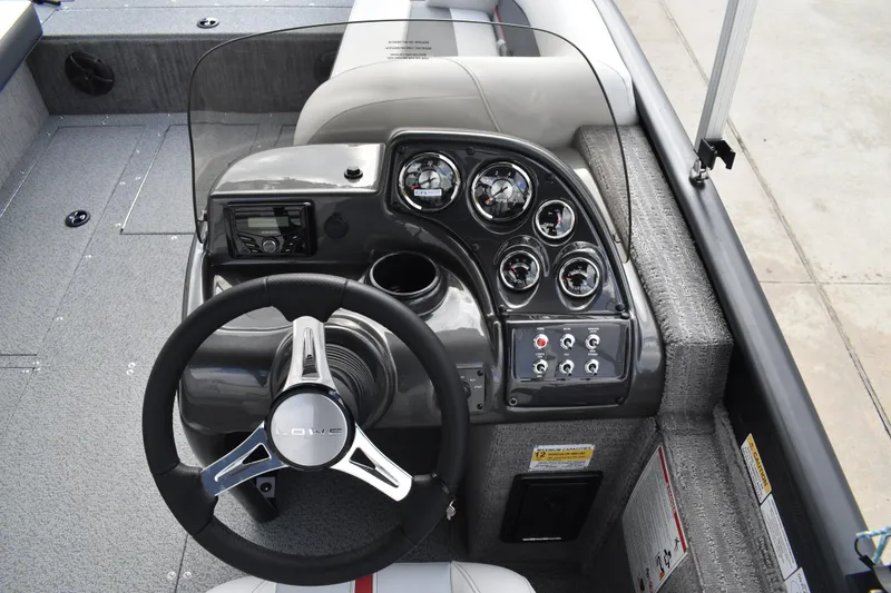 Slide: The Image of 2026 Lowe Sport Deck 224 boat dashboard with steering wheel and control gauges. - 47
