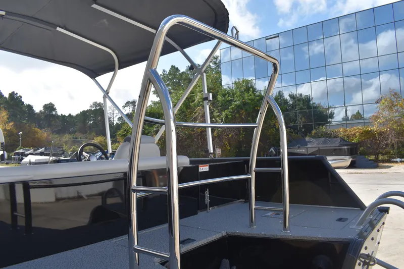 Slide: The Image of 2026 Lowe Sport Deck 224 boat with stainless steel ladder and canopy, outdoors. - 58