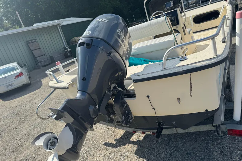 Slide: The Image of 2000 Carolina Skiff Semi-V 1980 boat with Yamaha 90 outboard motor in a yard. - 3