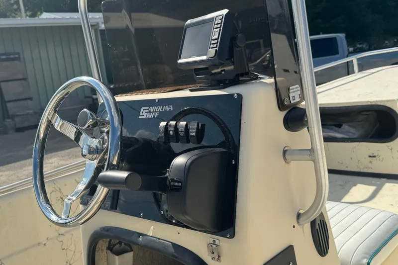 Slide: The Image of Steering console of a 2000 Carolina Skiff Semi-V 1980 boat with controls and display. - 5