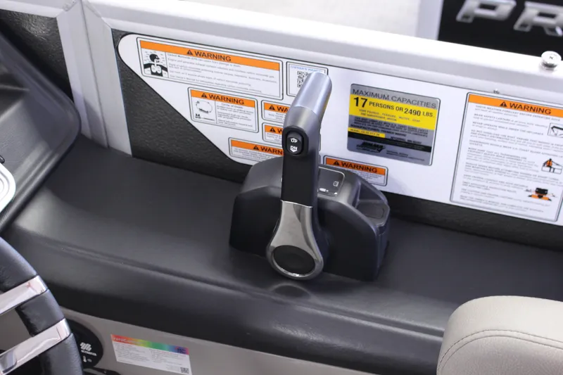 Slide: The Image of 2022 Premier Intrigue 230 Bed boat control panel with capacity warnings and throttle lever. - 10