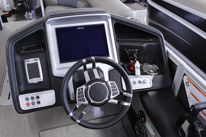 Slide: The Image of 2022 Premier Intrigue 230 Bed boat dashboard with steering wheel and control panel. - 12