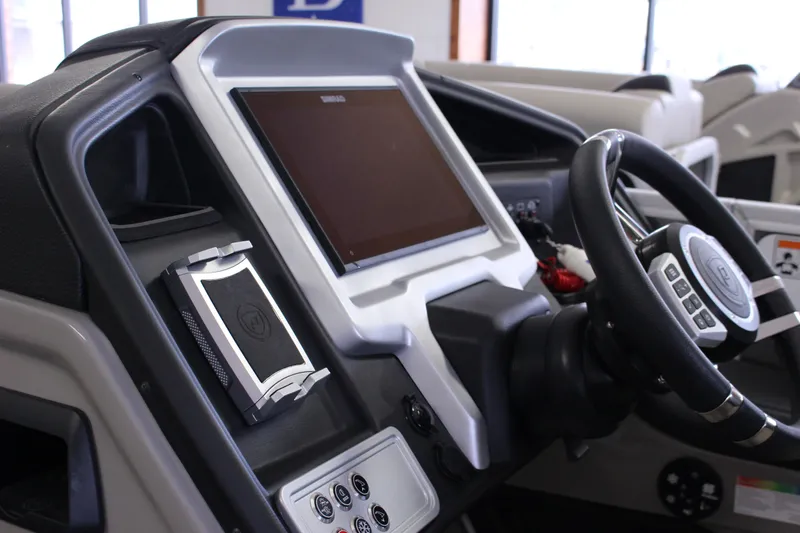 Slide: The Image of 2022 Premier Intrigue 230 Bed boat dashboard with steering wheel and control panel. - 18