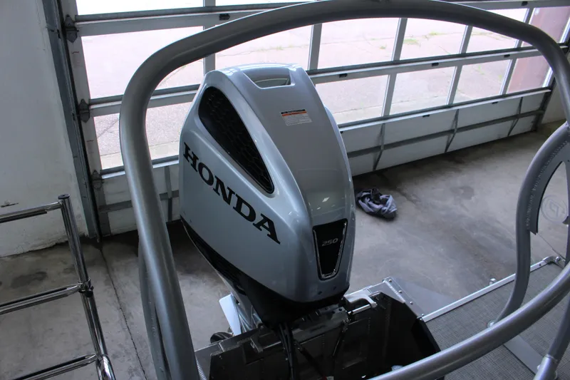 Slide: The Image of Honda 250 outboard motor on 2022 Premier Intrigue 230 Bed boat in garage. - 22
