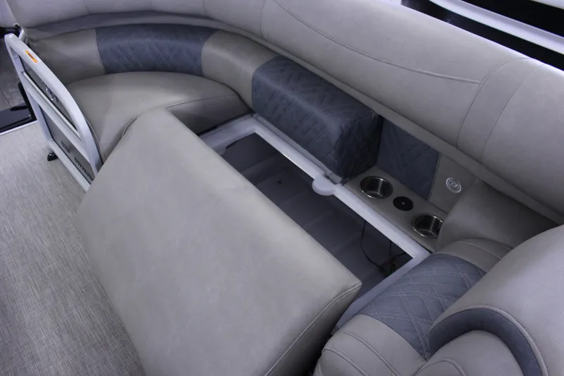 Slide: The Image of 2022 Premier Intrigue 230 Bed with gray seating, storage compartment, and cup holders. - 24