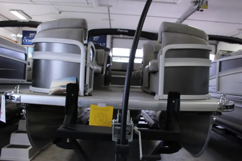 Slide: The Image of 2022 Premier Intrigue 230 Bed pontoon boat interior with plush seating in showroom. - 26