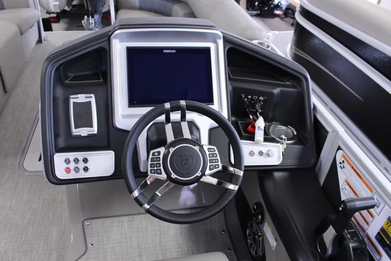 Slide: The Image of 2022 Premier Intrigue 230 Bed boat dashboard with steering wheel and control panel. - 9