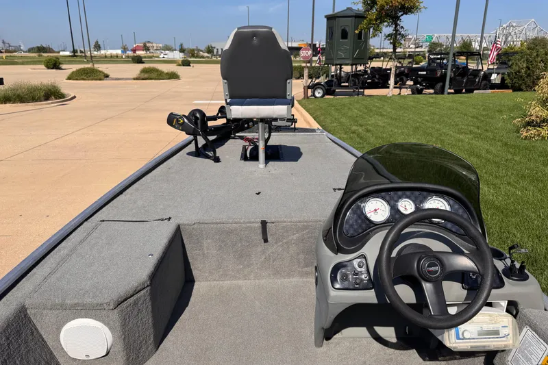 Slide: The Image of 2013 Tracker Pro165 boat interior with steering wheel and seating, parked outdoors. - 3
