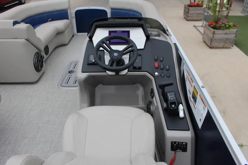 Slide: The Image of 2022 Premier Sunsation 230 boat interior with steering wheel and control panel. - 2