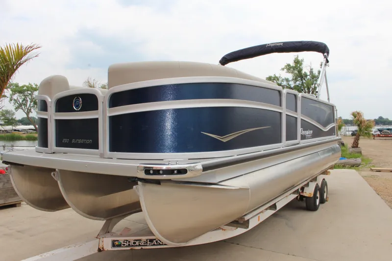 Slide: The Image of 2022 Premier Sunsation 230 pontoon boat on trailer, featuring sleek design and blue accents. - 9