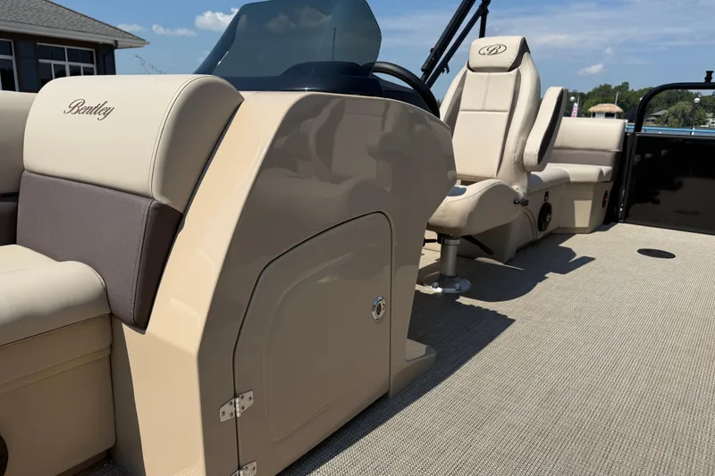 Slide: The Image of 2026 Bentley Pontoons Legacy 200 Navigator interior with beige seating and steering console. - 11