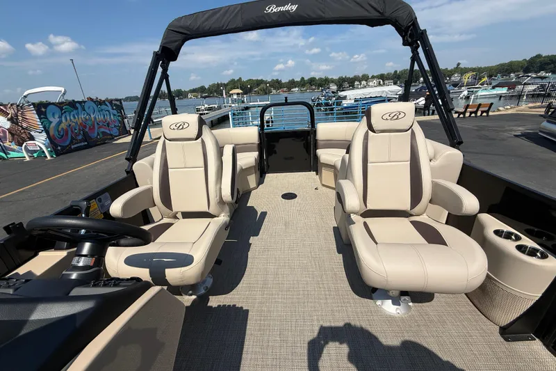 Slide: The Image of 2026 Bentley Pontoons Legacy 200 Navigator with beige seating, docked at a marina. - 24