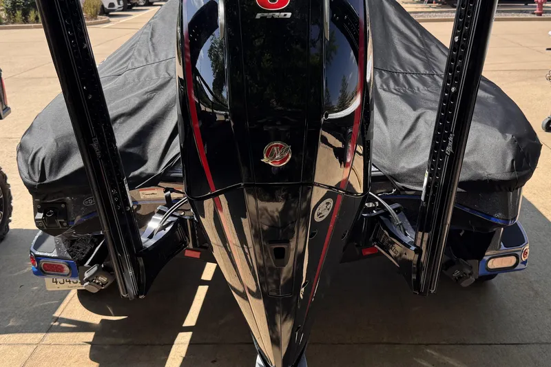 Slide: The Image of 2023 Triton 21TRXP boat with cover, rear view, parked outdoors. - 2