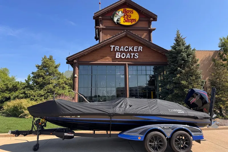 Slide: The Image of 2023 Triton 21TRXP boat covered, parked outside Bass Pro Shops Tracker Boats store. - 4