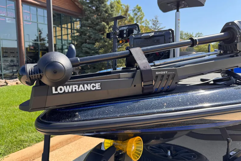 Slide: The Image of 2023 Triton 21TRXP boat with Lowrance Ghost trolling motor, outdoors near a building. - 5