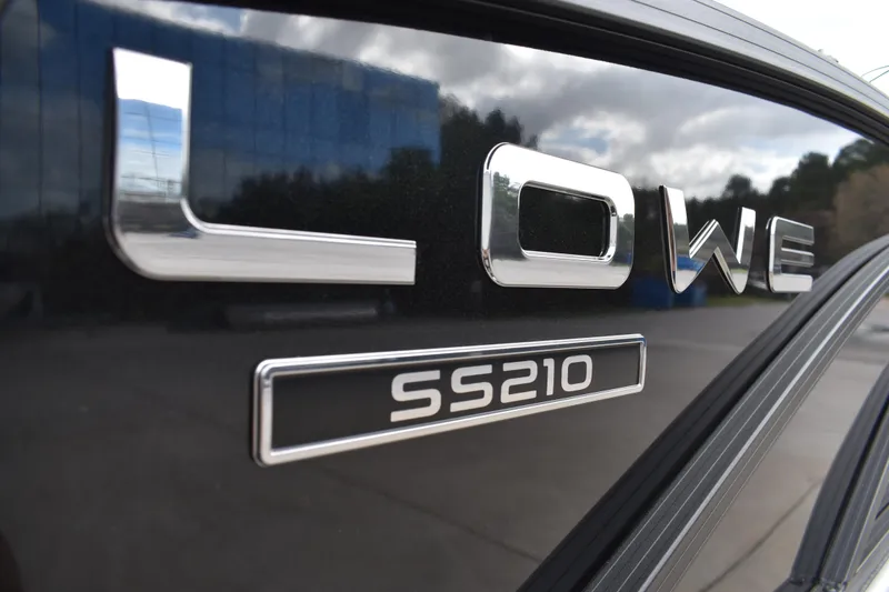 Slide: The Image of Close-up of 2026 Lowe SS 210 logo on a shiny black surface. - 4