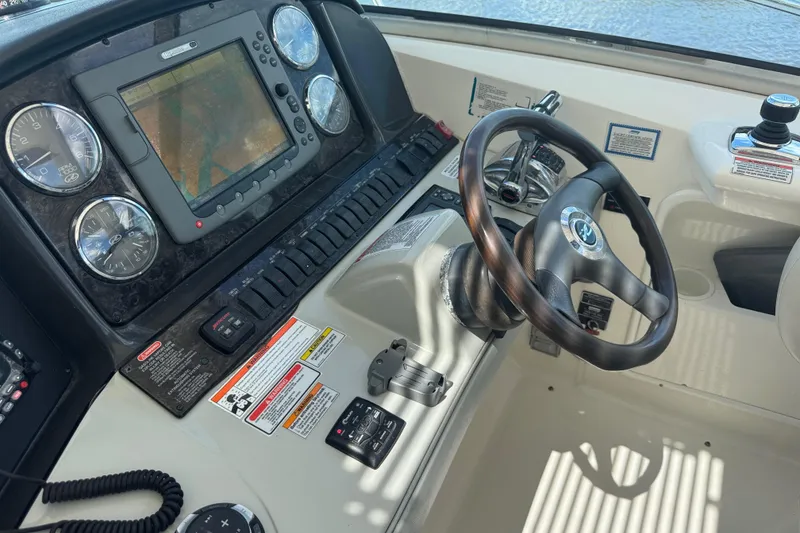 Slide: The Image of Dashboard of 2010 Sea Ray 390 Sundancer with steering wheel and navigation controls. - 17