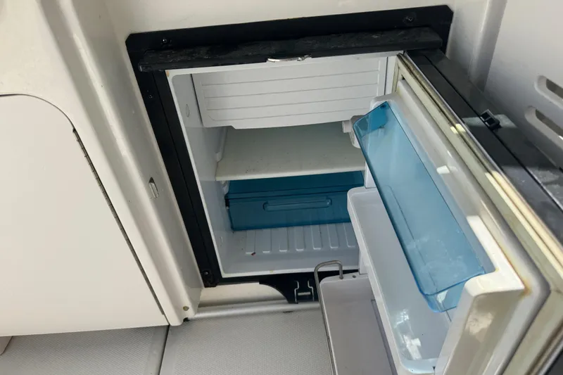 Slide: The Image of Open refrigerator on 2010 Sea Ray 390 Sundancer boat, showing interior shelves and compartments. - 24