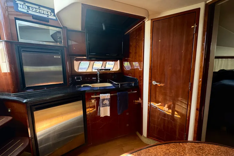 Slide: The Image of Luxurious interior of 2010 Sea Ray 390 Sundancer yacht with kitchenette and wood finishes. - 32