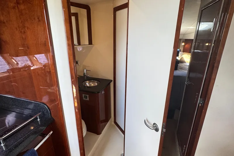 Slide: The Image of Interior of 2010 Sea Ray 390 Sundancer yacht, featuring a compact bathroom and bedroom. - 35