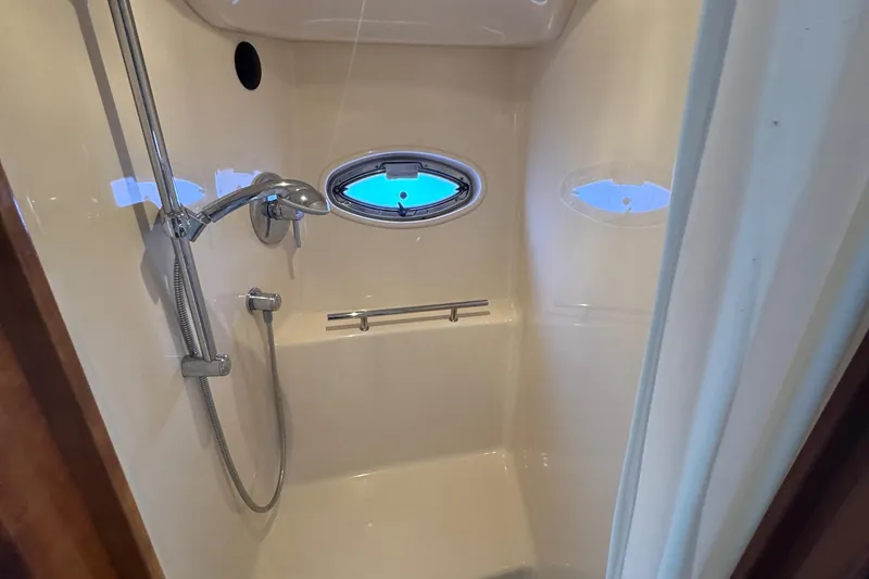 Slide: The Image of Shower area in 2010 Sea Ray 390 Sundancer yacht with chrome fixtures and porthole window. - 39