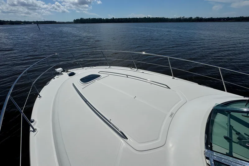 Slide: The Image of 2010 Sea Ray 390 Sundancer yacht on calm water under a partly cloudy sky. - 6