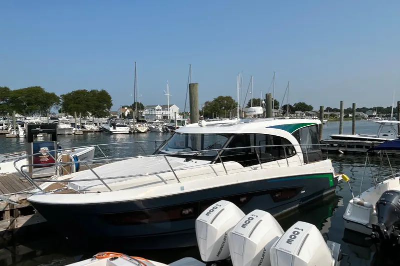 Slide: The Image of 2022 Beneteau Antares 11 docked at a marina, surrounded by other boats. - 0