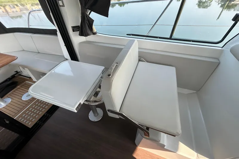 Slide: The Image of Interior of 2022 Beneteau Antares 11 with modern seating and foldable table. - 12