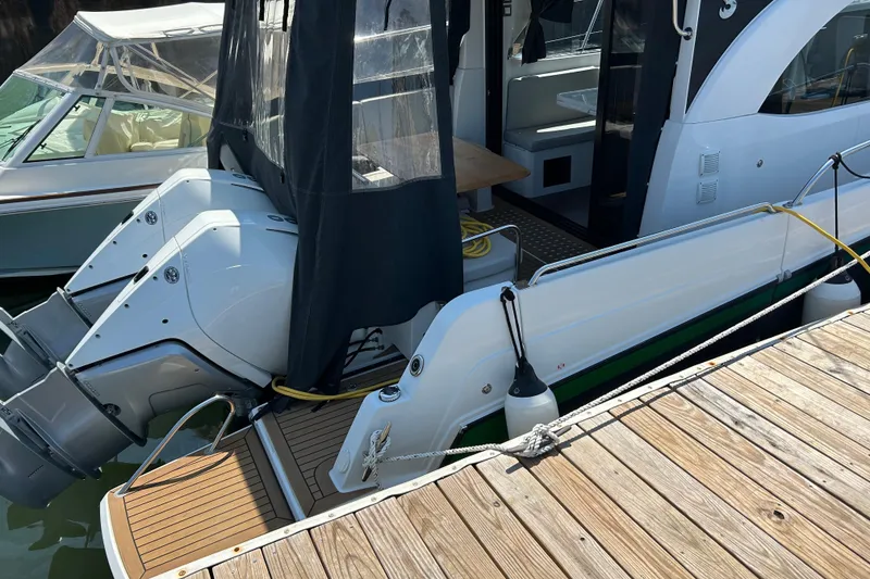 Slide: The Image of 2022 Beneteau Antares 11 docked, featuring dual outboard engines and a covered cockpit area. - 3