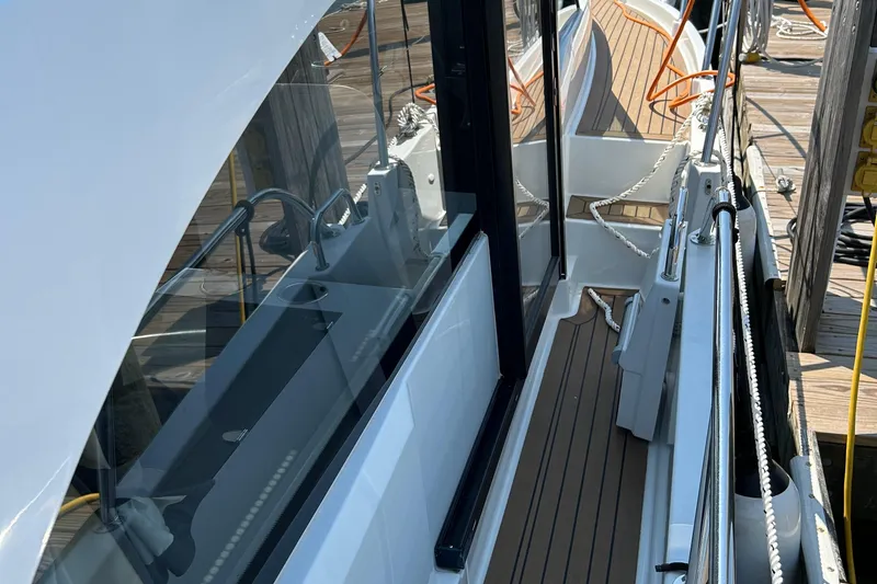 Slide: The Image of 2022 Beneteau Antares 11 yacht docked, showcasing sleek design and wooden deck details. - 4
