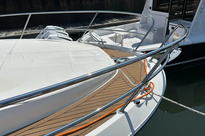 Slide: The Image of 2022 Beneteau Antares 11 boat deck with stainless steel railings and wood finish. - 5