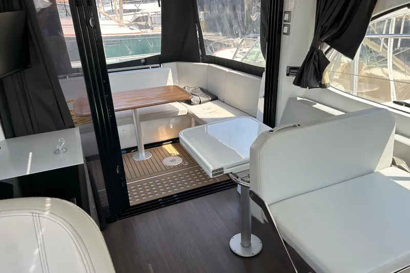 Slide: The Image of Interior of 2022 Beneteau Antares 11, featuring modern seating and wooden table. - 8