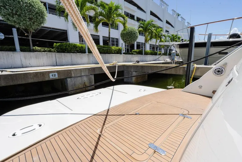 Slide: The Image of 2006 Aicon Flybridge yacht docked at marina with wooden deck and lush surroundings. - 12