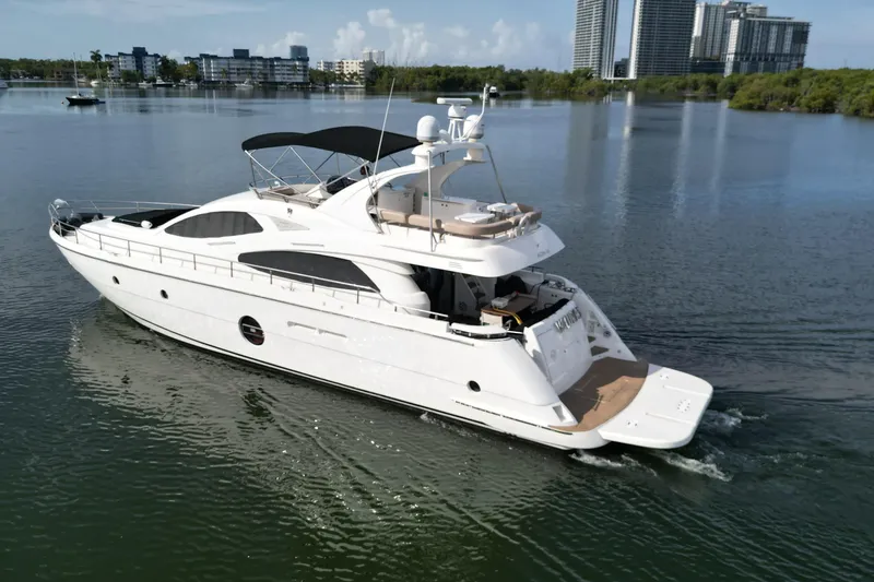 Slide: The Image of Aicon Flybridge 2006 yacht cruising on calm waters near modern cityscape. - 2