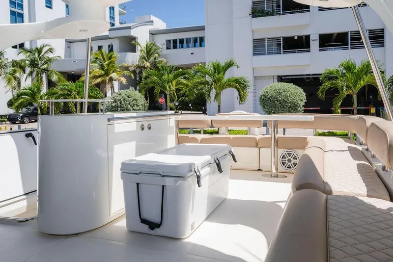 Slide: The Image of Luxurious 2006 Aicon Flybridge yacht deck with seating and cooler, surrounded by palm trees. - 24