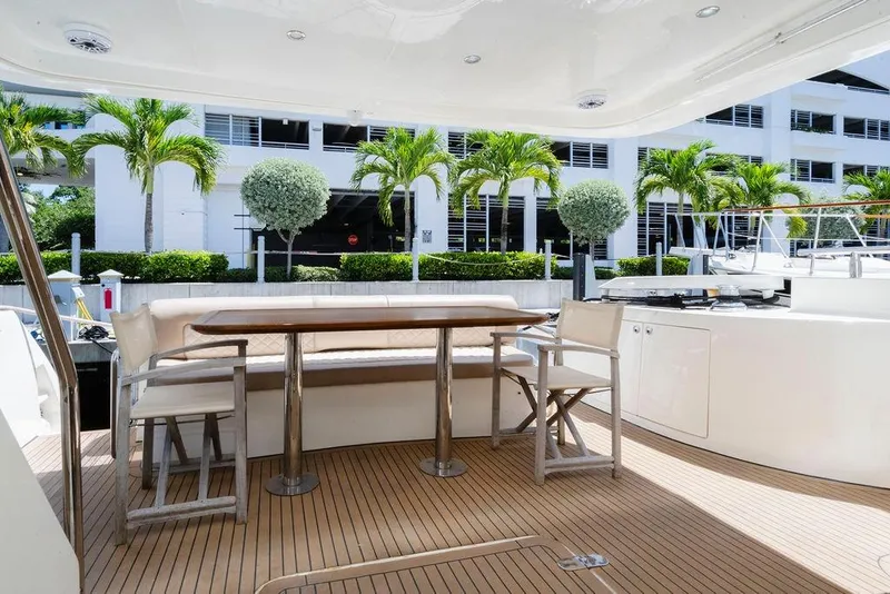 Slide: The Image of Luxurious 2006 Aicon Flybridge yacht deck with seating, table, and tropical backdrop. - 27