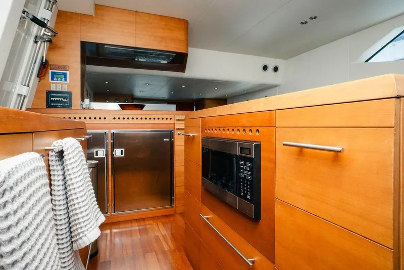 Slide: The Image of 2006 Aicon Flybridge yacht kitchen with wooden cabinetry, stainless steel appliances, and modern design. - 45