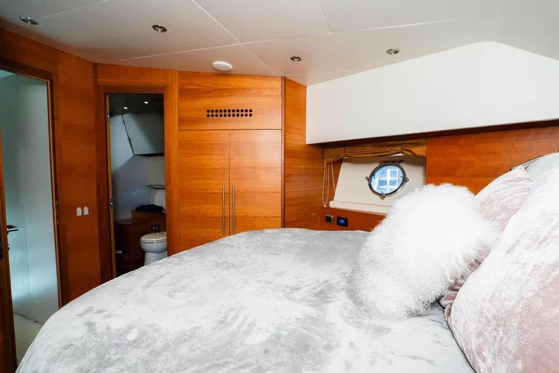 Slide: The Image of Luxurious 2006 Aicon Flybridge yacht bedroom with wood paneling and plush bedding. - 91