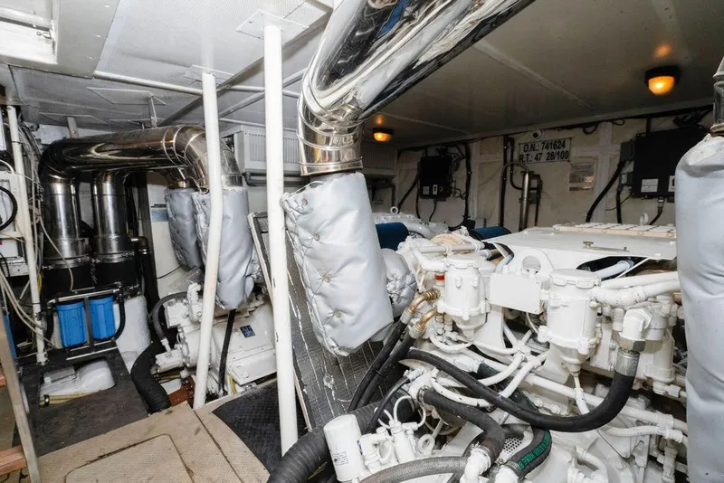 Slide: The Image of Engine room of a 2006 Aicon Flybridge yacht, featuring complex machinery and piping. - 96
