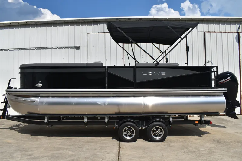 The Image of 2026 Lowe LF232 TL pontoon boat with black canopy, parked on a trailer. - 1