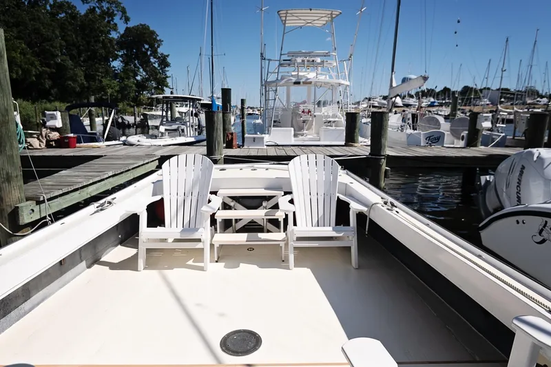 Slide: The Image of 1972 Jarvis Newman Downeast boat docked with white chairs on deck. - 11