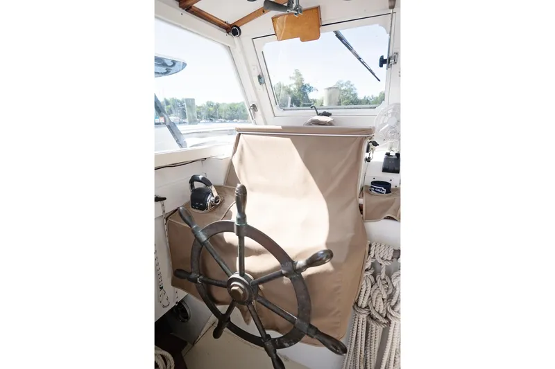 Slide: The Image of 1972 Jarvis Newman Downeast boat helm with wooden wheel and covered controls. - 14